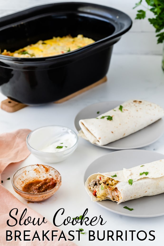 crockpot in background with two breakfast burritos on a plate