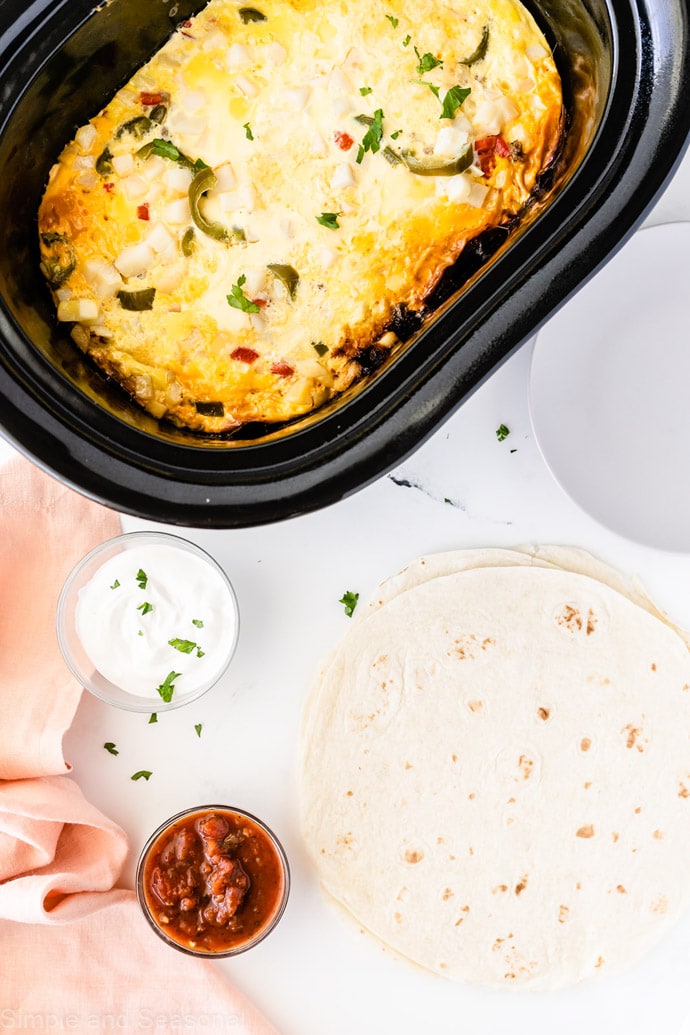 cooked breakfast burrito mixture with empty tortillas on the plate