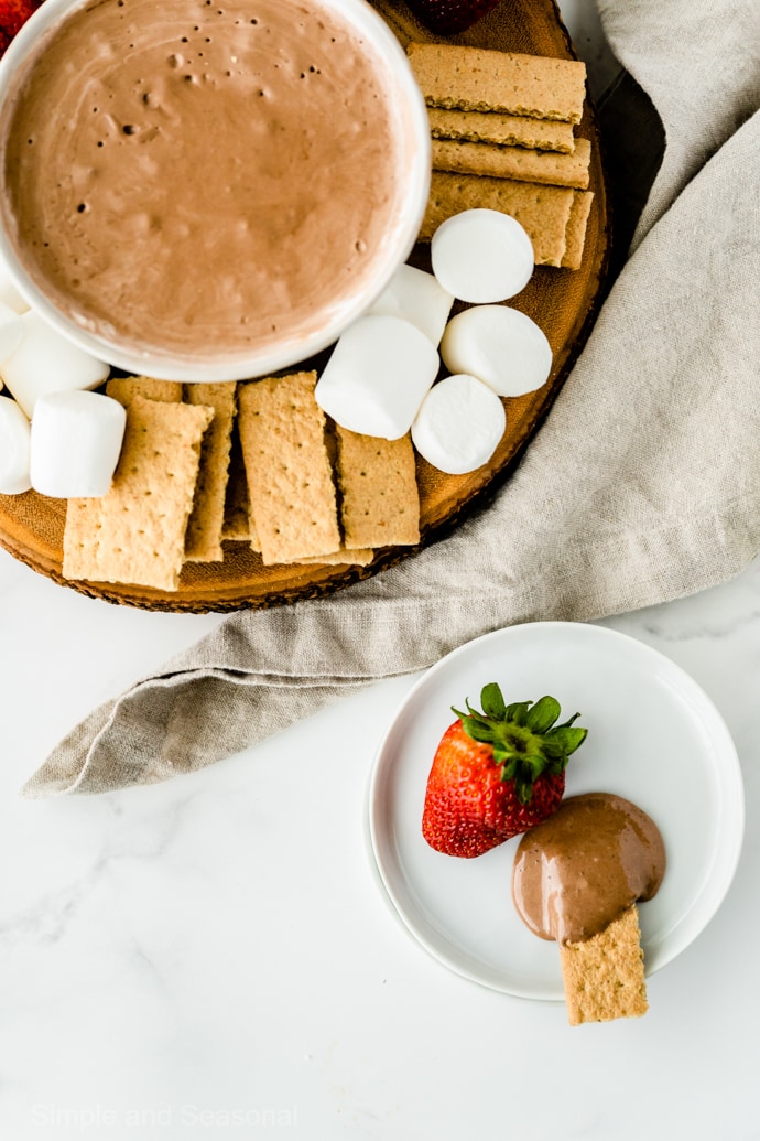 dipped strawberry and graham cracker on a plate