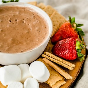 closeup of wooden platter holding s'mores dip and dipping food