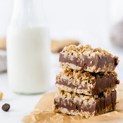 stack of three oatmeal bars with jar of milk in the background