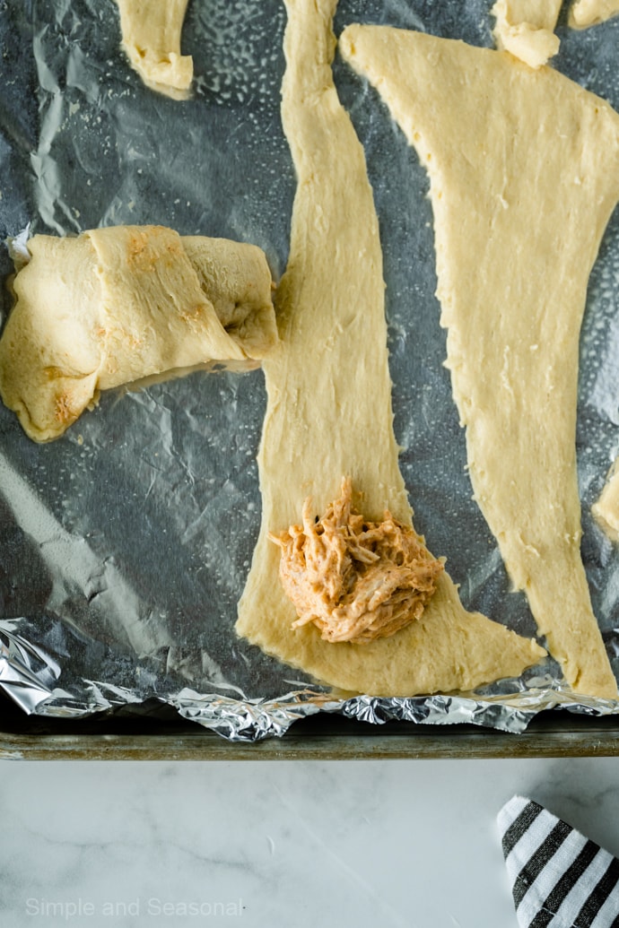 crescent roll dough on a baking sheet lined with foil