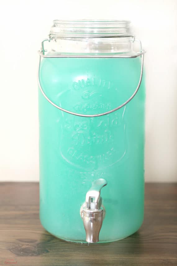 clear drink dispenser filled with baby blue punch