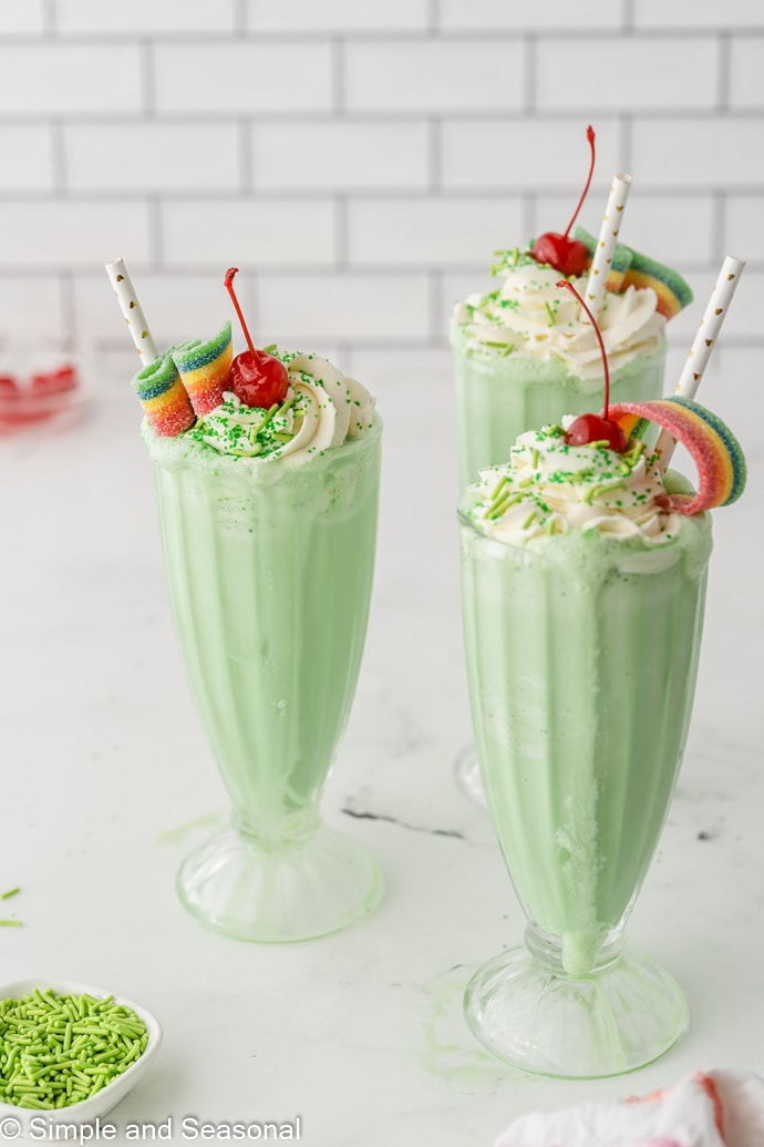 3 copycat shamrock shakes in tall glasses and topped with sprinkles