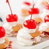 cherry topped cookies filled with marshmallow cream and dipped in white candy