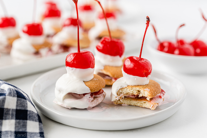 cherry marshmallow cookies on a white plate; one cookie has a bite taken out of it