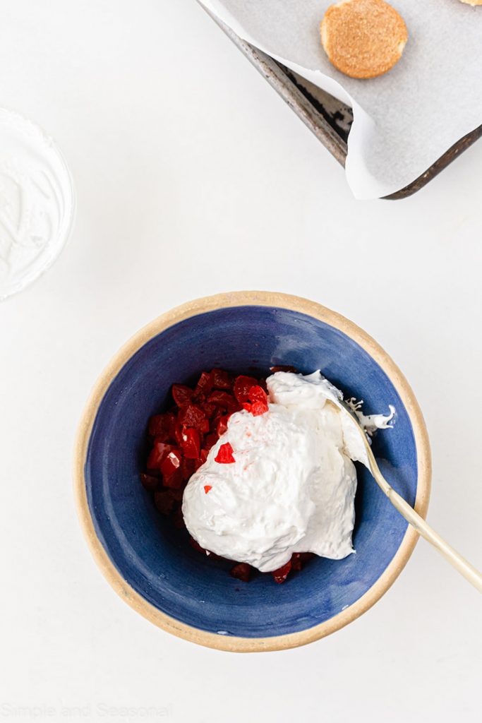 marshmallow cream and chopped maraschino cherries in a blue bowl