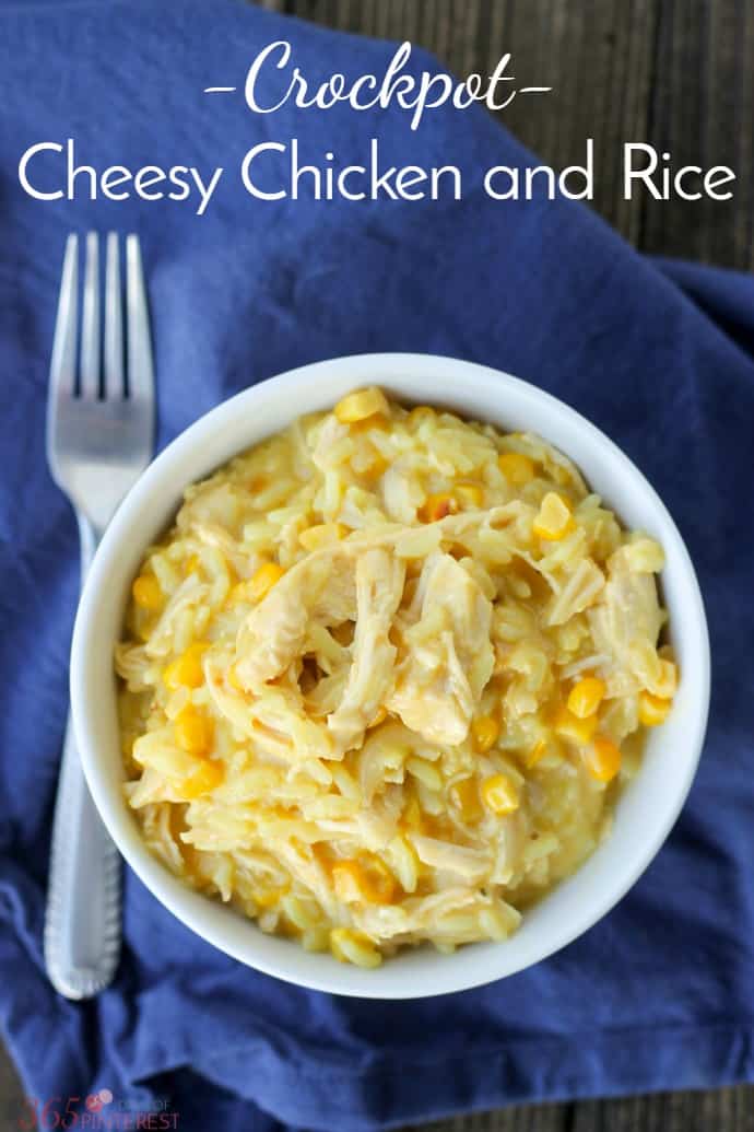 top down view of bowl of yellow rice and chicken on blue napkin; text label reads Crockpot Cheesy Chicken and Rice