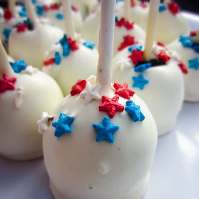 cookie pops decorated with and red and blue stars on a white plate