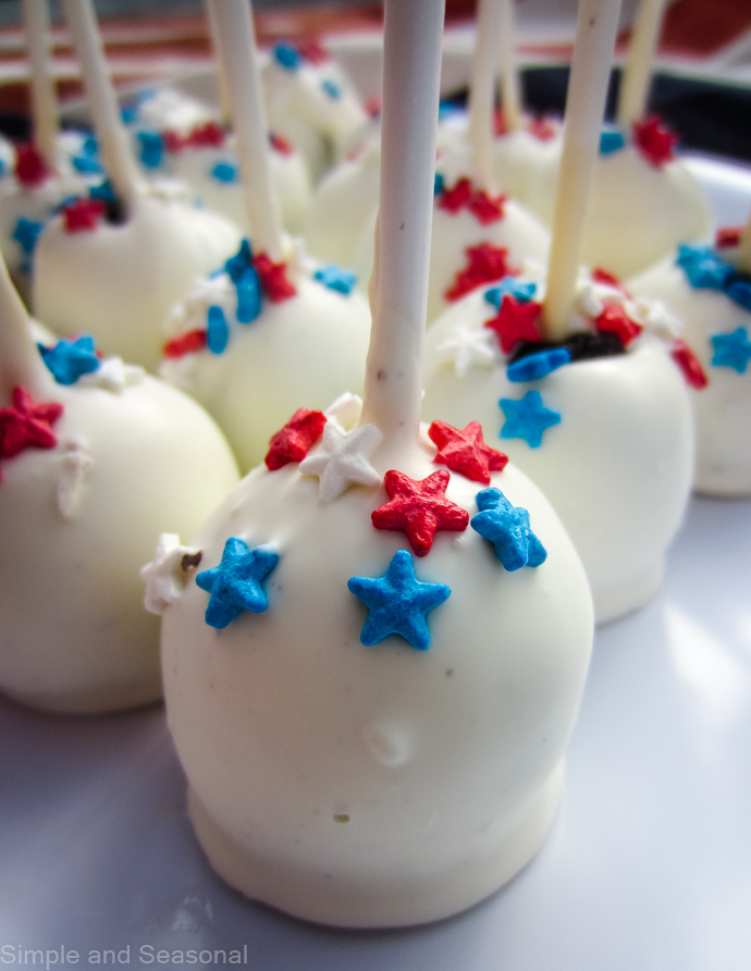 cookie pops decorated with and red and blue stars on a white plate