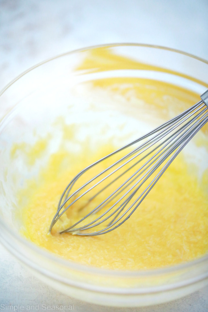 bowl of egg and butter mixture with whisk