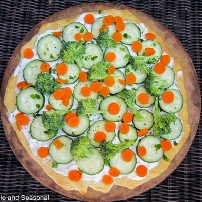 top down view of pizza topped with cream cheese and fresh vegetables