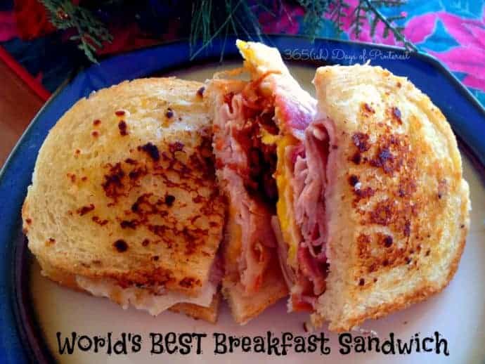 breakfast sandwich with crispy bread on blue plate with Christmas table in background