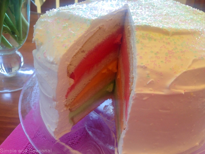 closeup of cake with slice removed showing pink, orange and green layers of sherbet