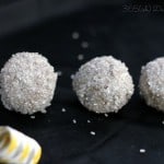 three glittery cookie balls with a noise maker on black background