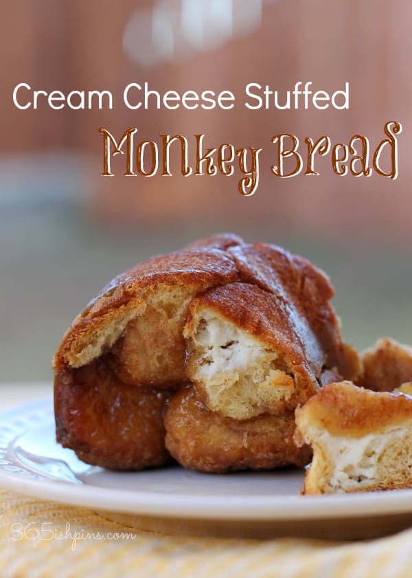 baked bread with cream cheese stuffing on a white plate; text label reads Stuffed Monkey Bread
