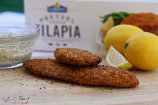 cooked fish fillets with tartar sauce and lemon