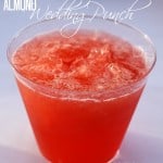 cup of red punch with partially frozen chunks; text overlay reads Almond Wedding Punch