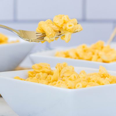 forkful of mac and cheese and white bowls