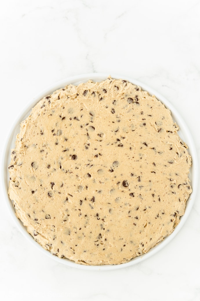 cookie dough spread on pizza pan for baking
