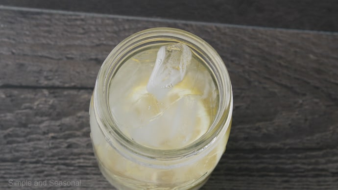 jar filled with water on top of the ice, lemon, and sugar