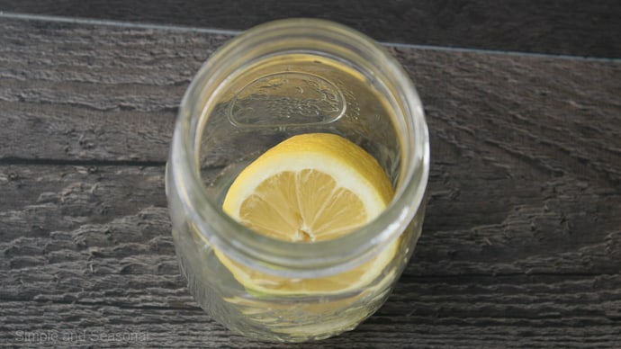 almost empty jar with lemon juice and half lemon inside