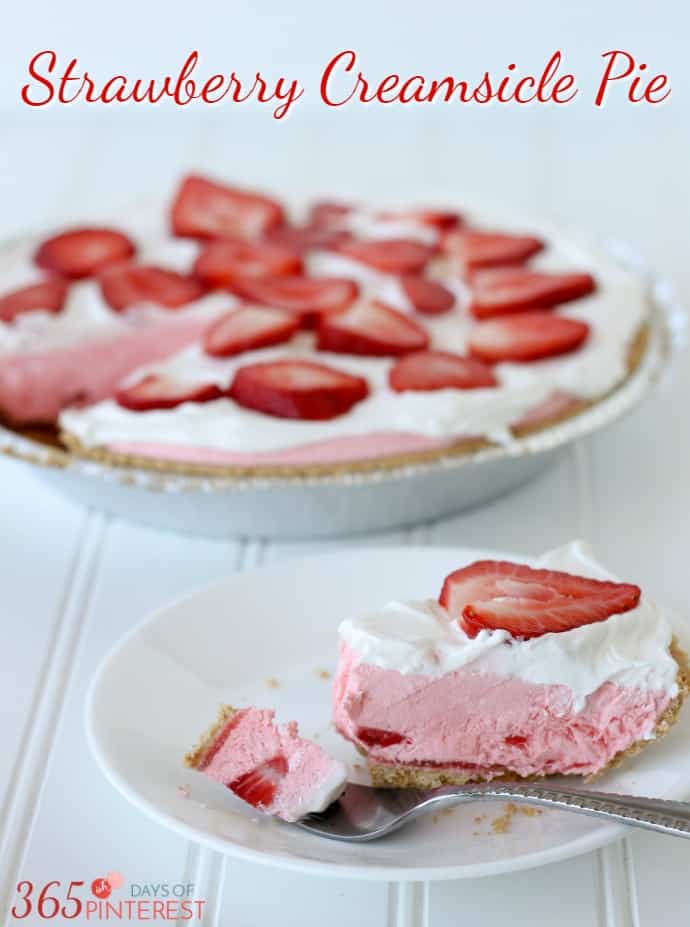 pink pie with chunks of strawberries and topped with whipped cream; text overlay Strawberry Creamsicle Pie