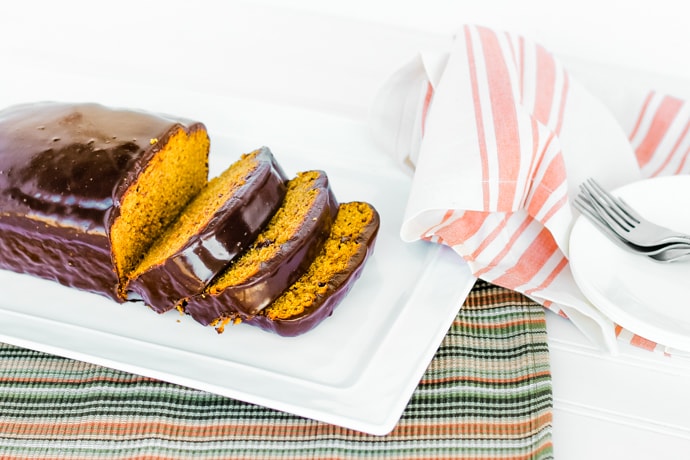 platter of pumpkin bread loaf, sliced, with plates and napkins