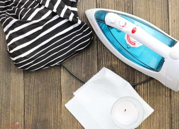 iron, dress, candle and paper towels on board background