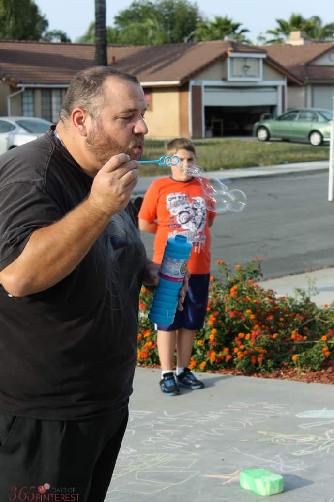 bubble blowing towards sidewalk chalk target