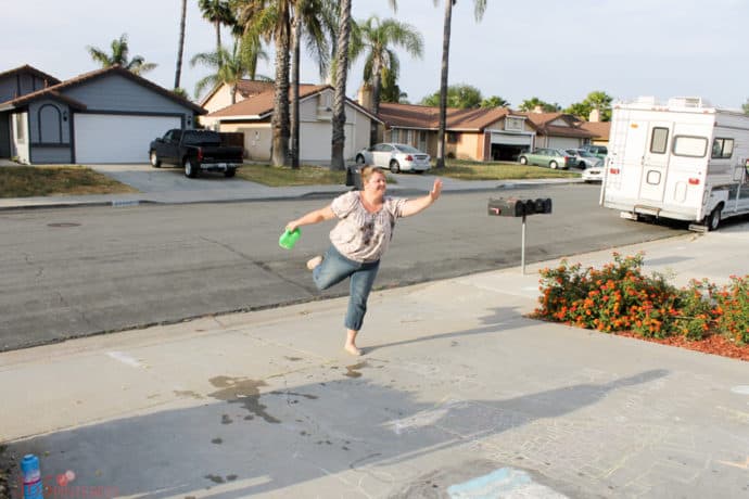 mom playing sponge toss sidewalk chalk game