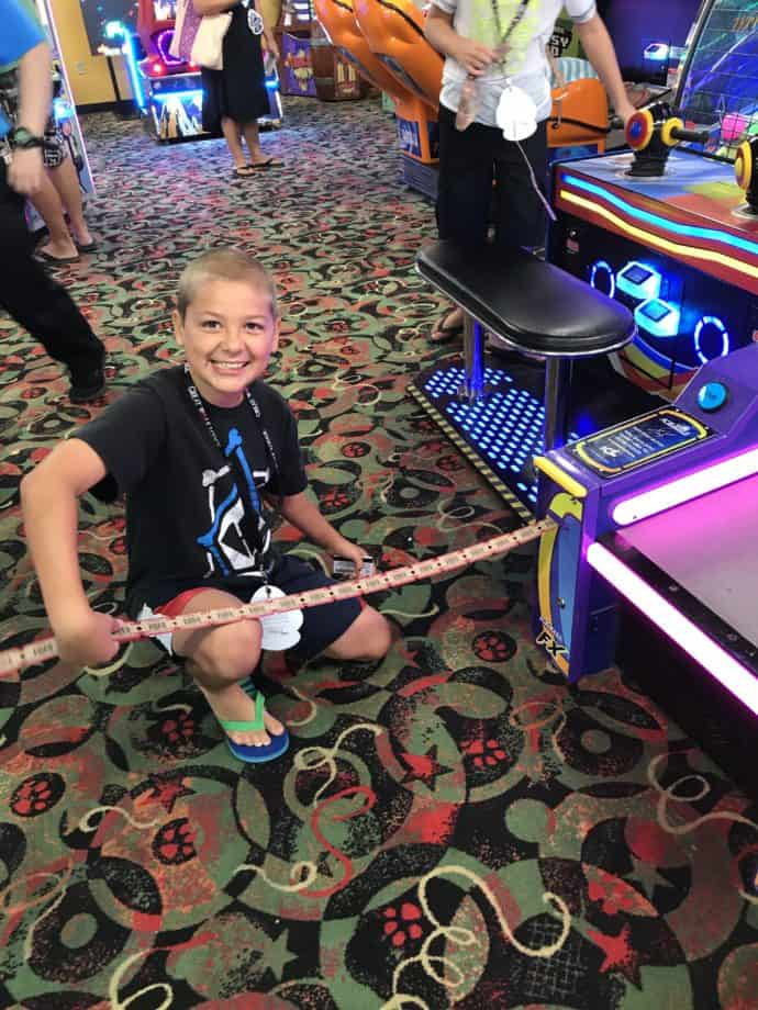 boy pulling tickets from an arcade game