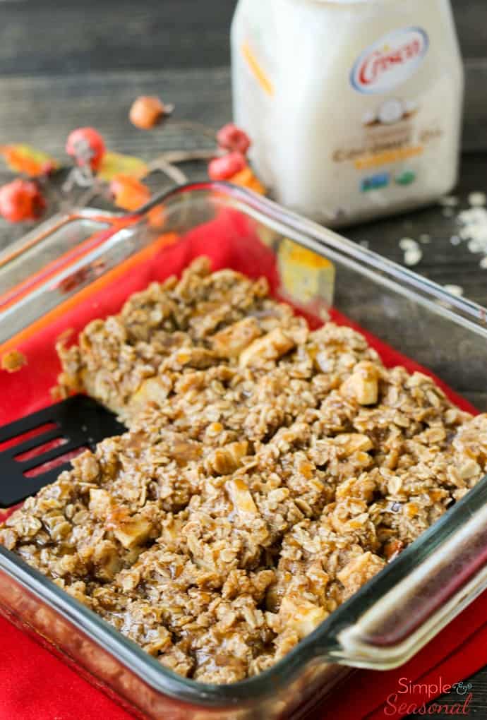 pan of caramel apple baked oatmeal on a wooden tabletop with red napkins