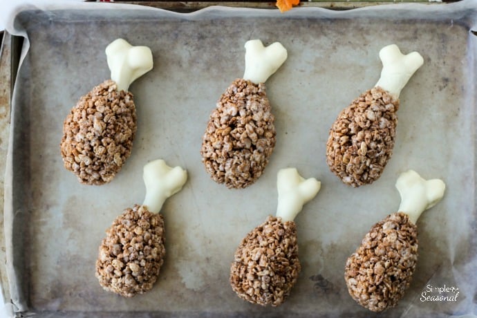 top down view of turkey legs made from cocoa krispies wrapped around dipped pretzel rods