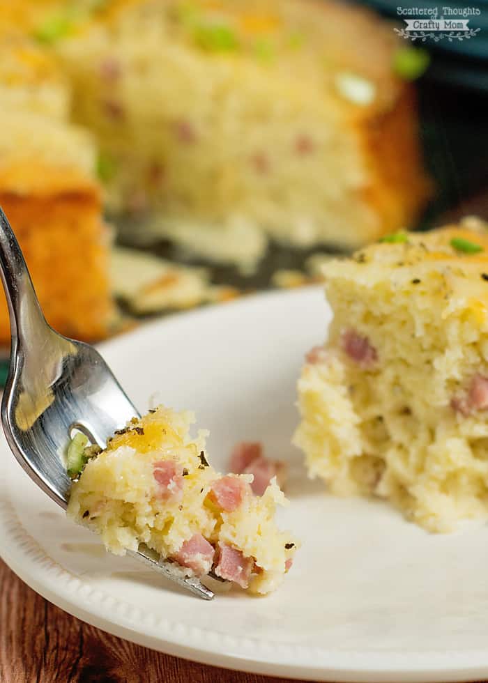 forkful of ham and cheese frittata on white plate