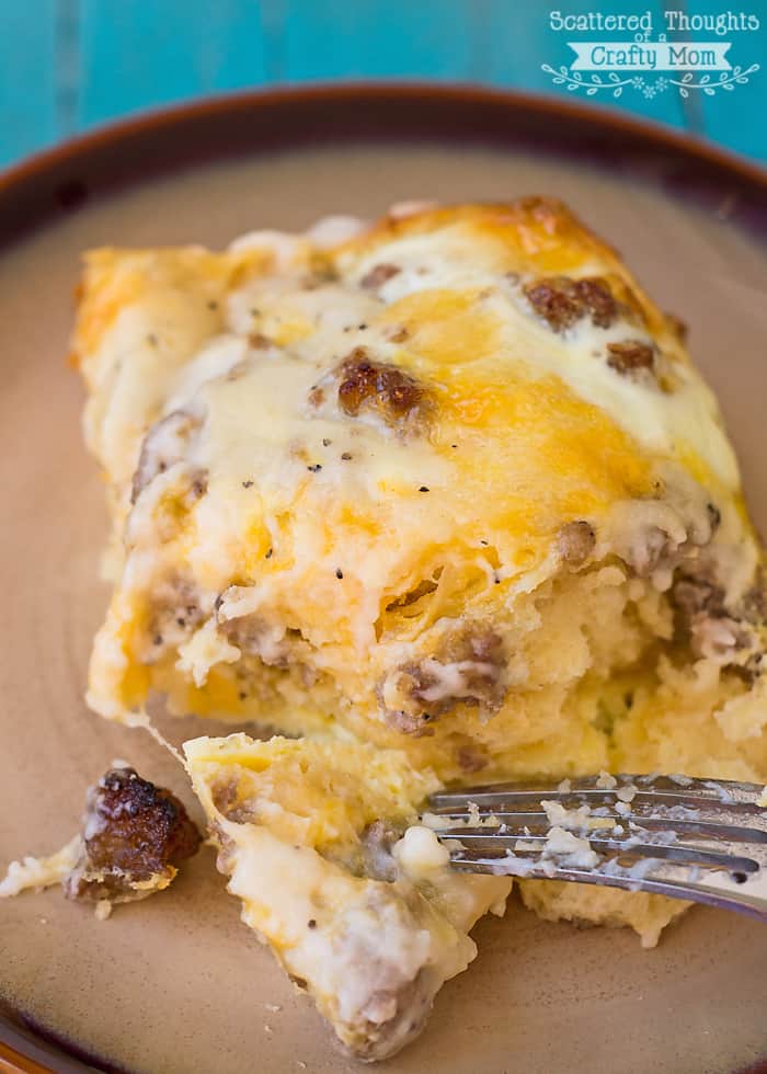 egg, sausage, biscuit and gravy casserole slice on a plate with fork