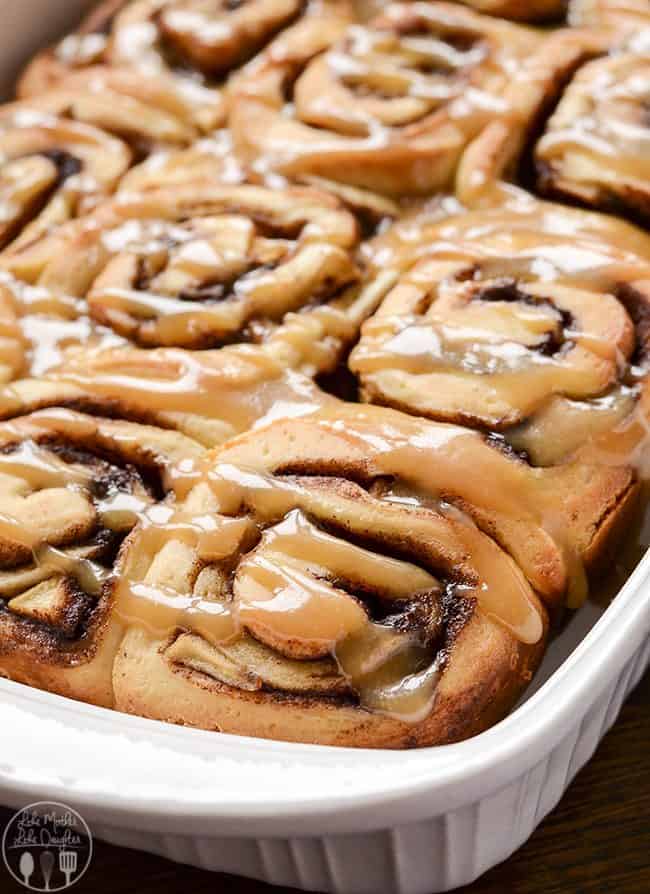 baked caramel apple cinnamon rolls in a white pan