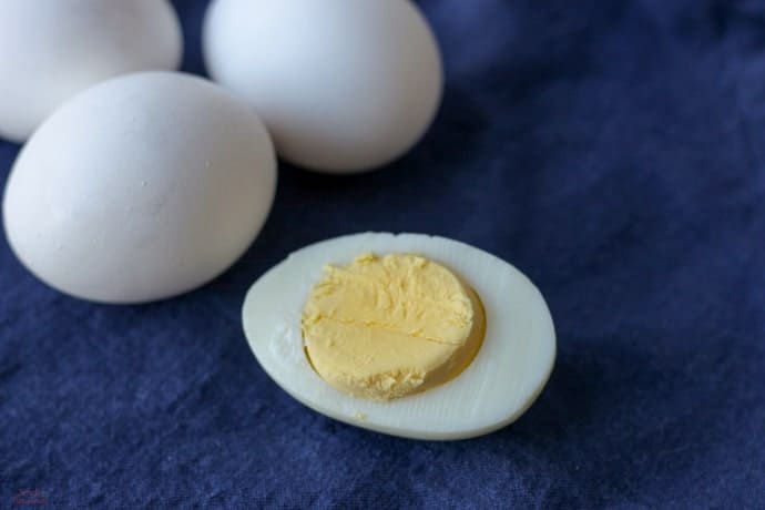 hard boiled egg sliced in half on blue background