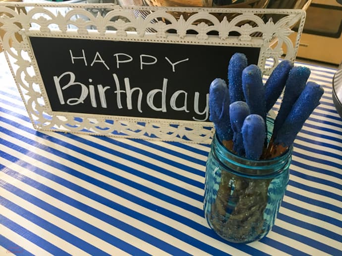 happy birthday sign next to blue dipped pretzel rods