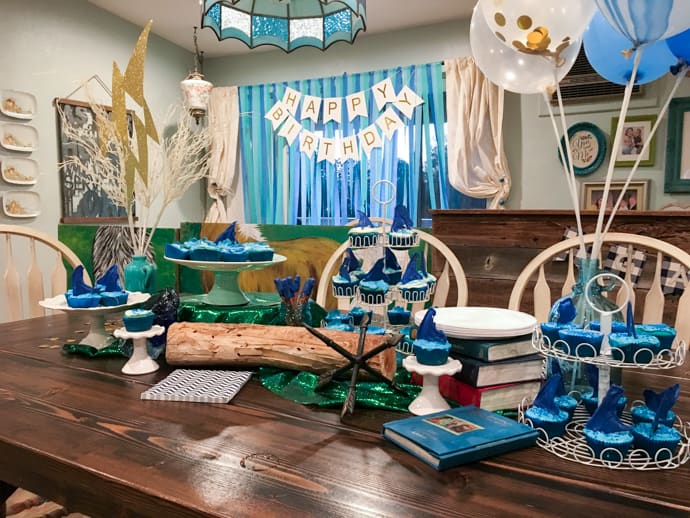 Percy Jackson party table with cupcakes and blue and green decor