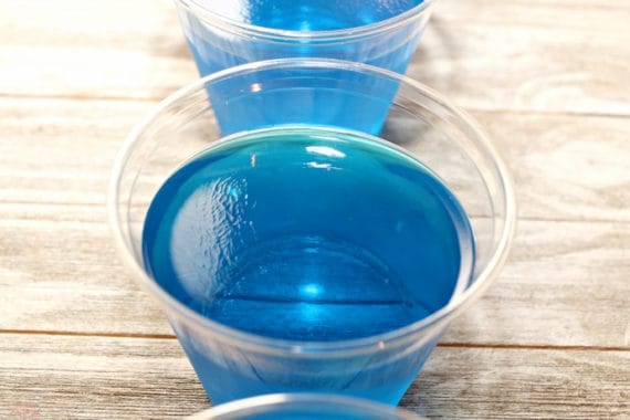 Cup with blue jello| Day at the Beach Jello Cups are perfect for a summer party. The best part is once everyone is done eating the yummy treat, you can just throw away the dishes! Try them for your next luau or pool party.