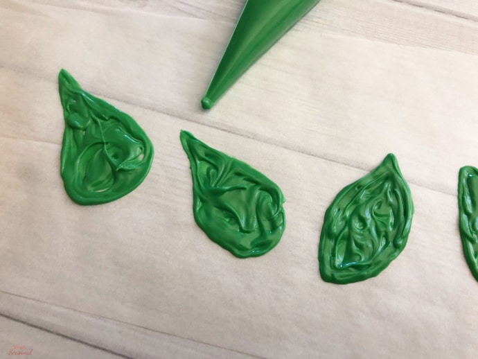 leaf shapes piped onto wax paper with green melting candy