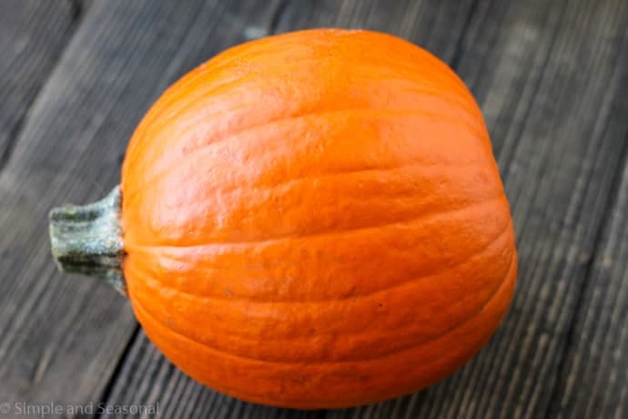 sugar pumpkin for baking on a wooden background