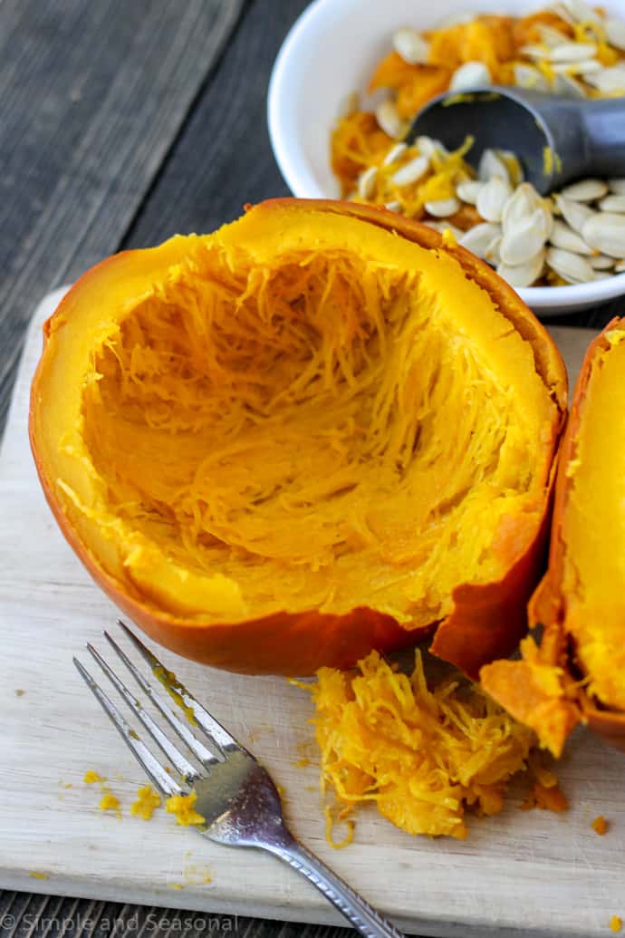 cooked pumpkin flesh with bowl of strings and seeds cleaned out