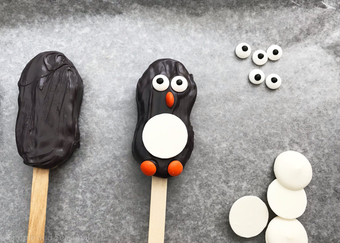 orange candy feet added to penguin cookie
