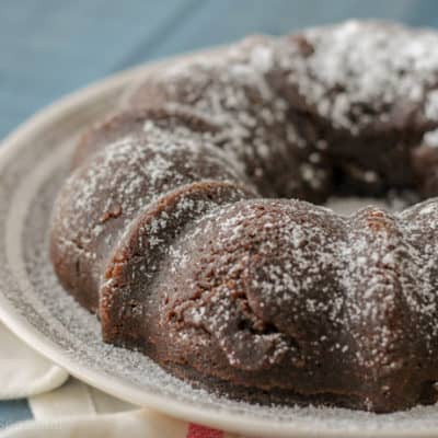 brownie ring dusted with powdered sugar on a white plate