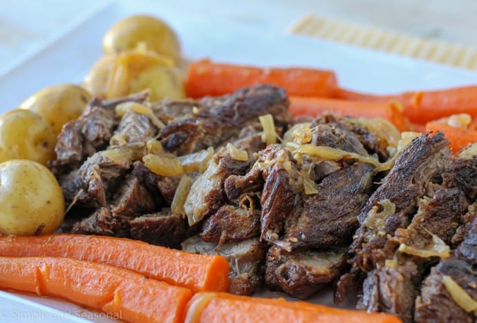 horizontal image showing cooked pot roast topped with cooked onion