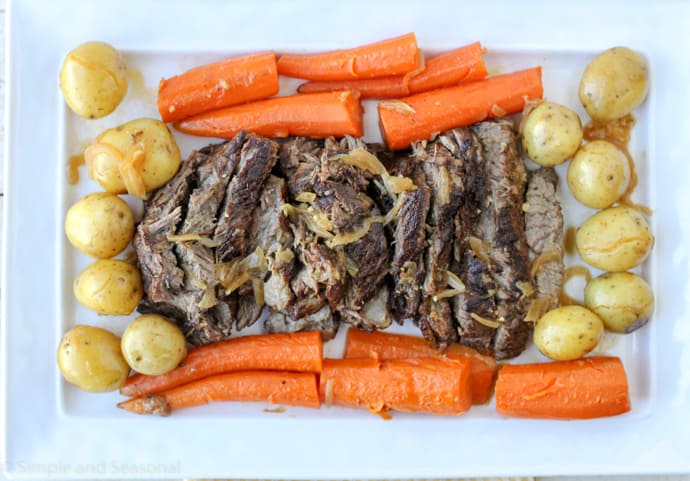 top down view of roasted chuck surrounded by carrots and potatoes