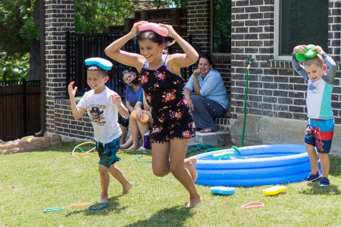 kids holding wet sponges on their heads and racing