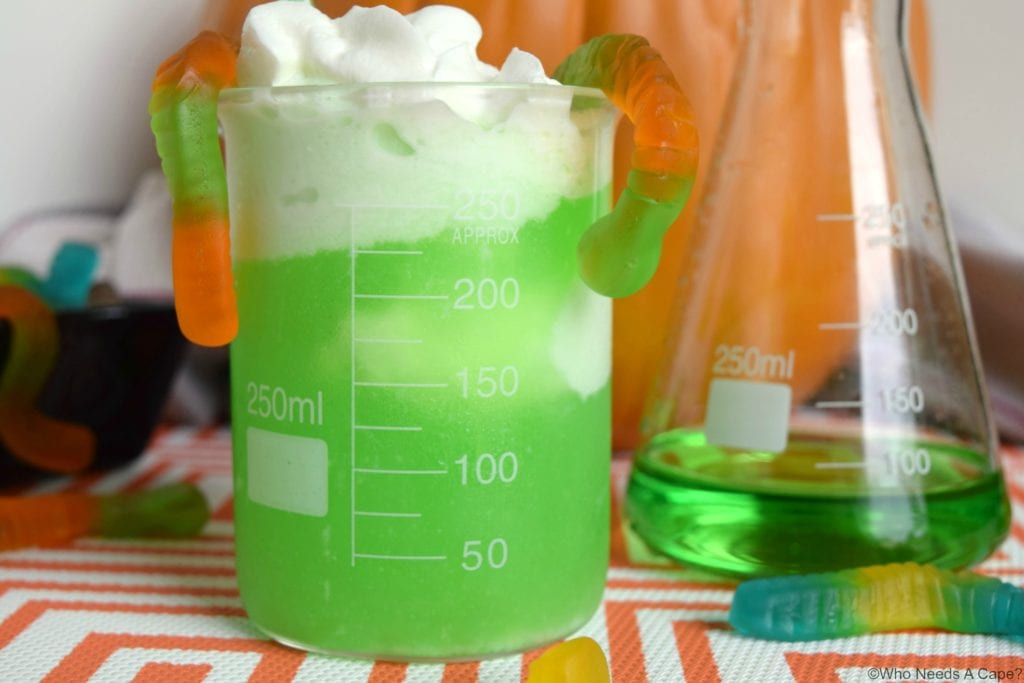 green drink in beaker with gummy worms on top